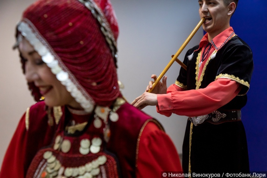 Артист башкирского фольклорного ансамбля играет на духовом музыкальном инструменте Курай