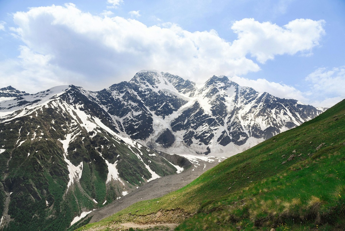 
Мончный вид прост: трава, снег, облака. На деле — разная поверхность и разный ветер на каждом десятке метров. Фото: Lola / Pexels