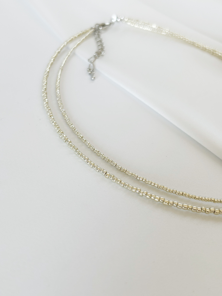 Блеск серебристого бисера будет деликатно переливаться на свету, привлекая внимание к изящной линии шеи.