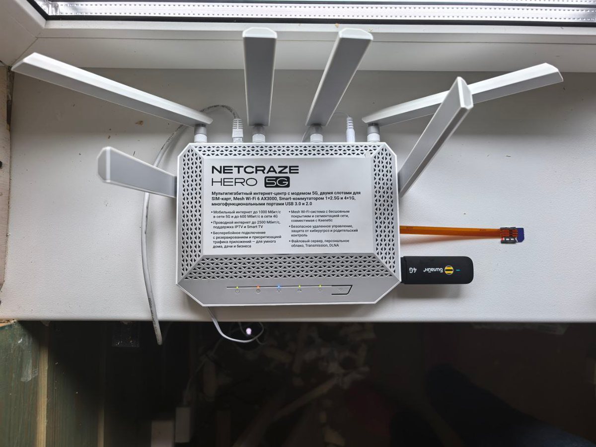 Netcraze Hero 5G на своём рабочем месте на подоконнике второго этажа. Экспериментальным путём выяснено, что это место лучшее. Виден второй модем и шлейф для SIM-карты: читайте дальше.