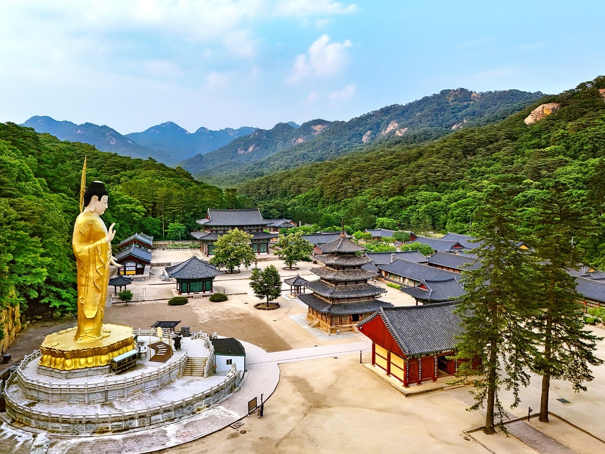 Панорамный вид на храм Попджуса. Видны позолоченная бронзовая статуя Великого Будды и зал Пхальсанджон в центре храма. https://www.yna.co.kr/view/AKR20240614013400542