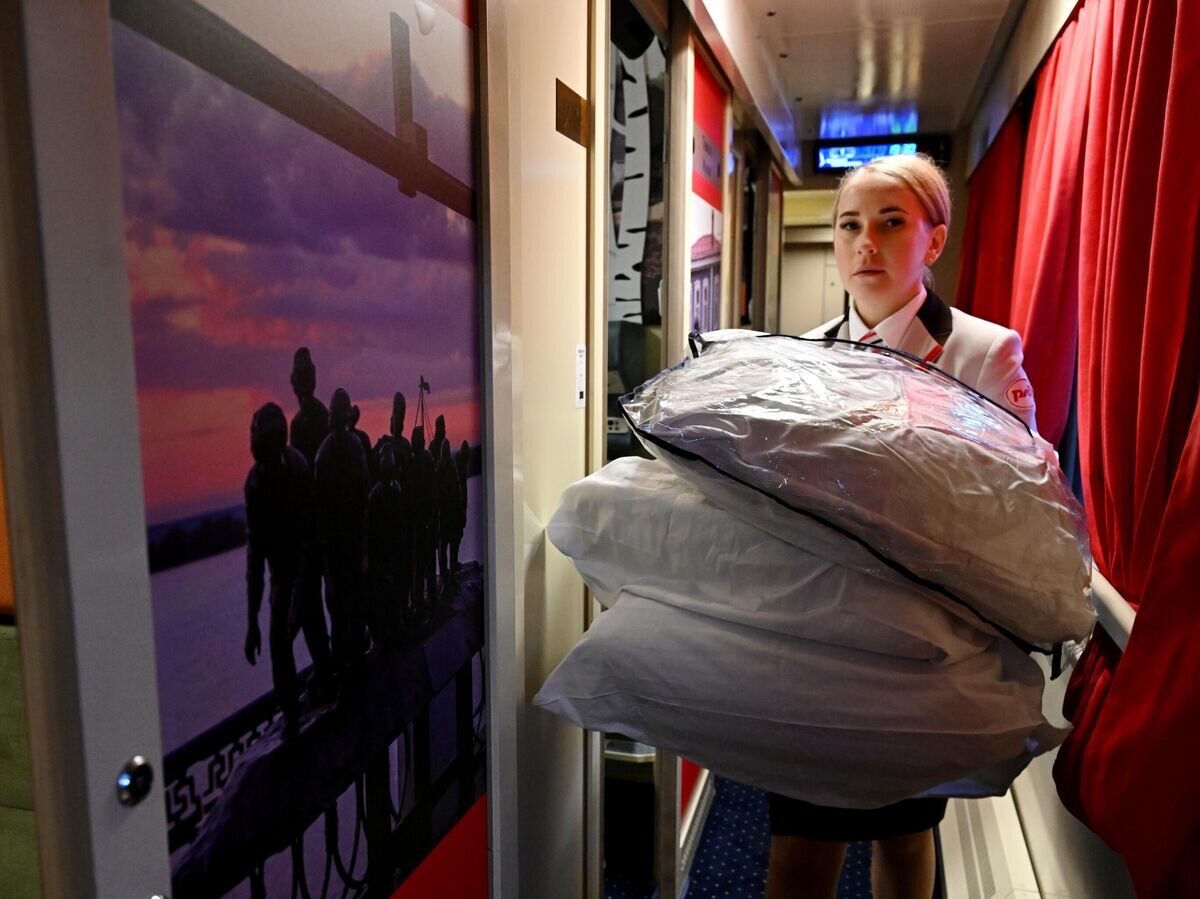    Проводница несет комплекты постельного белья пассажирам туристического вагона "КультСамара" в составе фирменного поезда № 9/10 "Жигули" (Москва - Самара) на Курском вокзале в Москве© РИА Новости / Григорий Сысоев