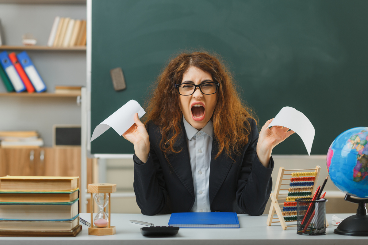 источник фото: https://ru.freepik.com/free-photo/angry-young-female-teacher-wearing-glasses-tear-paper-sitting-desk-with-school-tools-classroom_28148020.htm#fromView=search&page=1&position=6&uuid=fc0958e0-735e-4a76-b96c-d11cc20e6ba3&query=злой+учитель+кричит