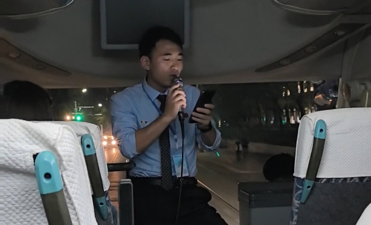 Наш гид Мун поет песню и подглядывает слова в мобильном телефоне.