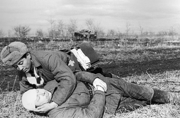 Помощь раненому оказывает военфельдшер. Великая Отечественная война
