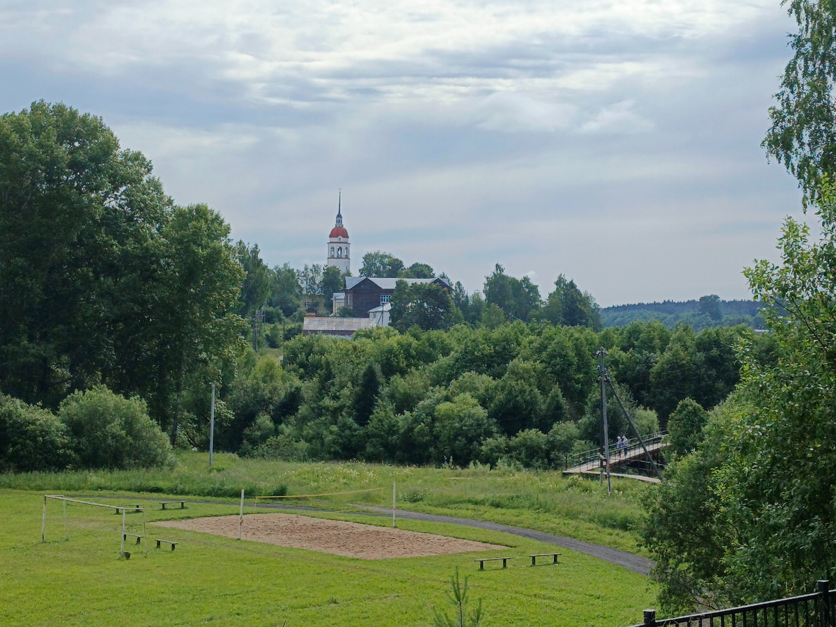 За Самым длинным мостом на другой стороне долины речки Песья Деньга видна колокольня Успенского собора, стоящая на берегу реки Сухоны.