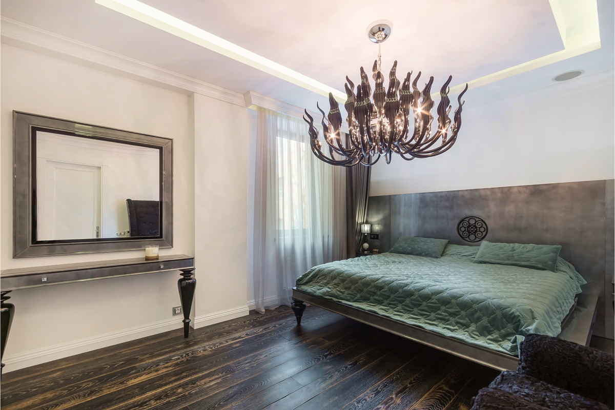 Элементы готики, например массивные люстры и фигурные мебельные ножки, дизайнеры органично вплетают в достаточно типовые современные интерьеры. Это сразу же делает комнату более загадочной и утонченной.