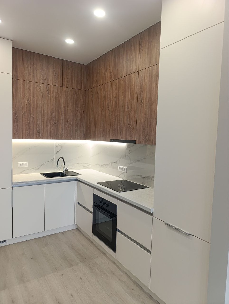 Кухня в сочетании белого и орехового оттенков, с подсветкой и встроенной техникой;