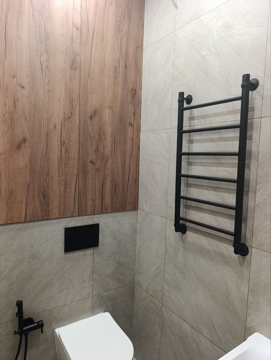 Ванная в светлом керамограните, с чёрной сантехникой и тёплыми деревянными панелями;