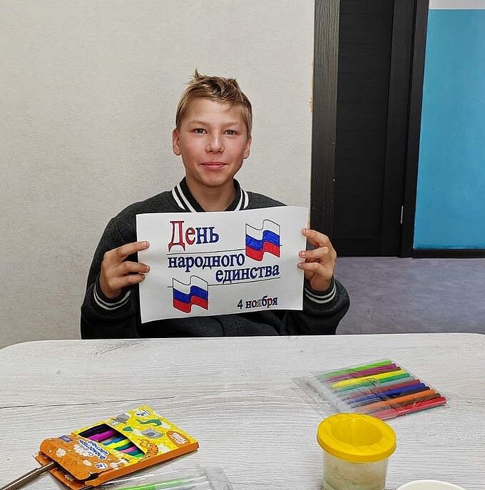 Мальчик показывает раскрашенную открытку