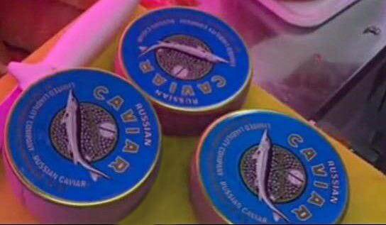Покупатель за 100 тыс. рублей приобрел 5 кг черной икры, расфасованной в синие металлические круглые банки с надписью Caviar (икра).