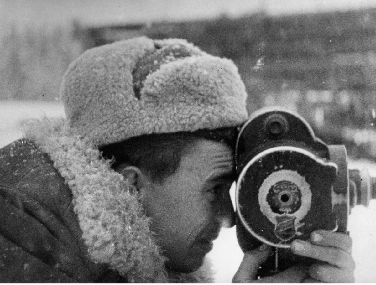 Фронтовой оператор [Л.Коробов]? во время ВОВ. 1942-1944. Госкаталог. Федеральное государственное бюджетное учреждение культуры "Государственный центральный музей кино". Пошейное профильное изображение оператор [Л.Коробова] в тулупе, ушанке с ручной кинокамерой
