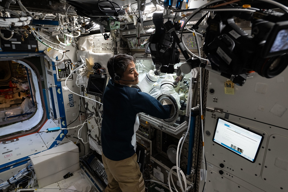 Кимия Юи работает в перчаточном боксе MSG в ЛЬ Destiny. Фото: spacenews.com