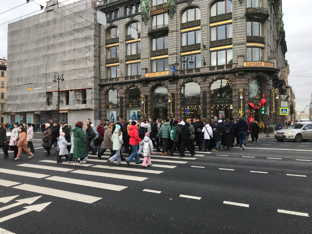 Детвора с взрослыми переходят Невский проспект от Казанского собора к Дому книги