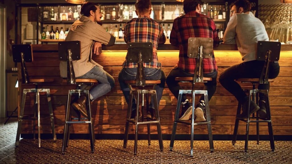 Вот так сидят за барной стойкой. Ноги — на подставке, локти — на стойке