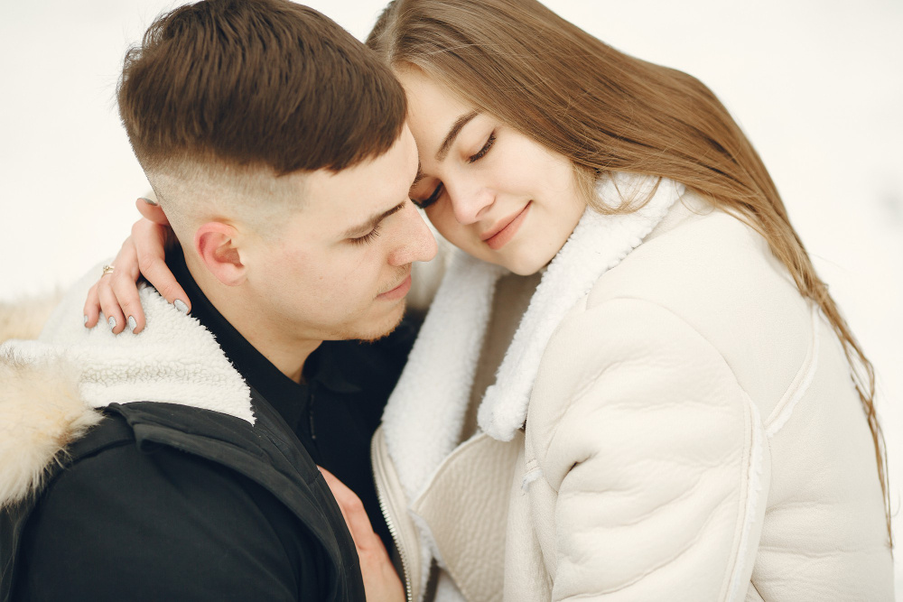 Мужчина и женщина обнимаются и улыбаются, прижавшись друг к другу — символ равновесия, нежности и зрелой любви в отношениях.