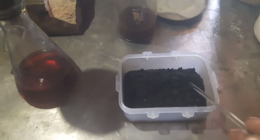 Недавно я получил посылку от своего подписчика Кирилла, который живёт в Канаде. Внутри оказалась небольшая коробка с необычным материалом — серыми хлопьями, представляющими собой осадки из чанов после фиксации изображения на цветной киноплёнке. По словам Кирилла, в этом материале может содержаться до **70% серебра**, и я решил проверить это на практике.
 **Первичные наблюдения и подготовка материала**

Вес содержимого составил **268 граммов**. В интернете я не нашёл ни одного упоминания о переработке именно таких осадков — ни видео, ни статей. Поэтому решил провести серию собственных экспериментов, чтобы выяснить, насколько реально извлечь серебро из этого материала и каким способом лучше это делать.
Всего я провёл **пять (и более)** опытов, которые растянулись почти на две недели. В результате собрал целую коллекцию наблюдений и промежуточных результатов.
 **Первый этап — электролиз**

Для начала я применил метод электролиза. В качестве анода использовал нержавеющую пластину, а катодом служила серебряная. Процесс протекал при напряжении около **3 В и токе 0,5 А**. Уже через два часа на дне ёмкости осели тяжёлые частицы, а сверху образовалась светлая шапка — признаки выделения серебра.

После фильтрации и сжигания осадка образовалась небольшая бусинка серебра. Пусть она была грязной и с примесями, но это подтвердило: метод рабочий.
**Второй этап — осаждение цинком и другими реагентами**

Далее я экспериментировал с другими способами — осаждением серебра сплавом **ЦАМ (цинк + алюминий)**, а также сульфидом и сульфитом натрия. В каждом случае получался тёмный мелкодисперсный осадок, который затем обрабатывался азотной кислотой.
Реакции протекали по-разному, но серебро присутствовало во всех вариантах, что только подогревало интерес к продолжению опытов.
**Подробный анализ и проверка содержания серебра**

Чтобы определить точное содержание серебра, я взял **50 граммов** исходного сухого материала и прошёл весь процесс заново:

1. Прокипятил осадки в воде, чтобы удалить