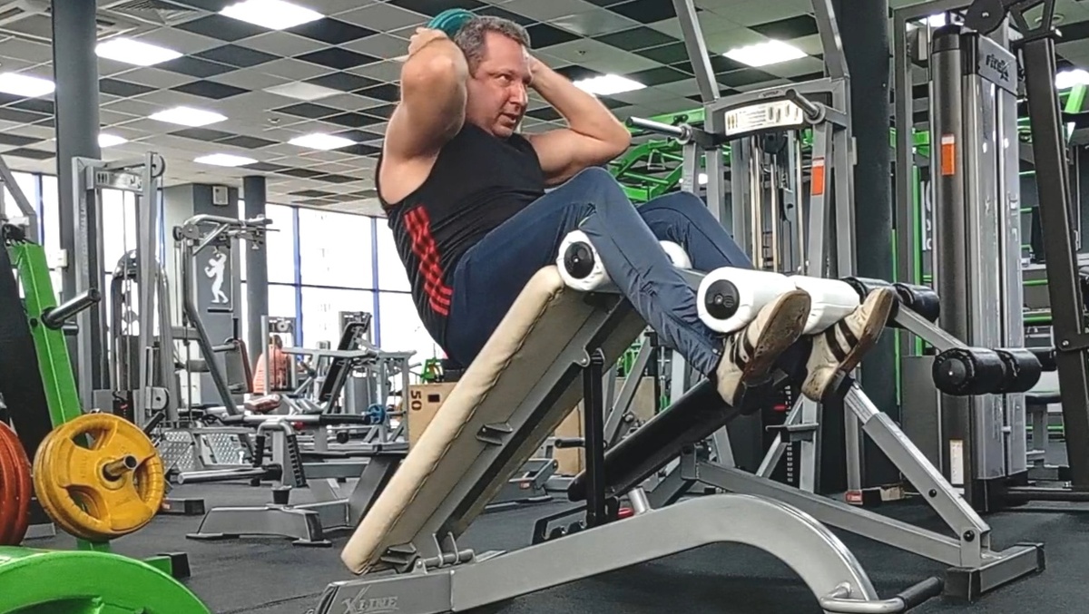 Подъём туловища на наклонной доске с небольшим отягощением... 