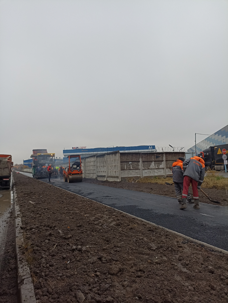 Укладка верхнего слоя асфальта на новом тротуаре 