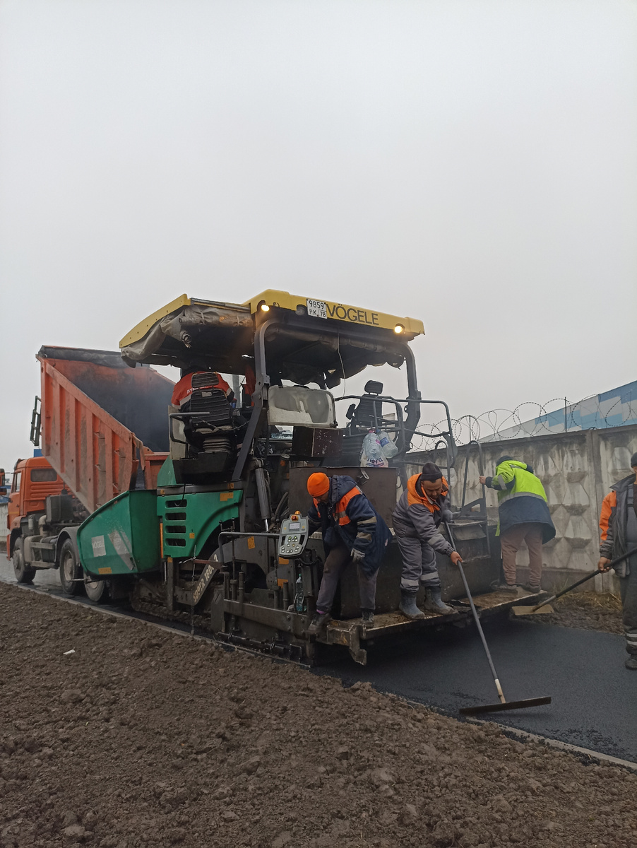 Эта машина укладывает асфальт а самосвал выгужает его 