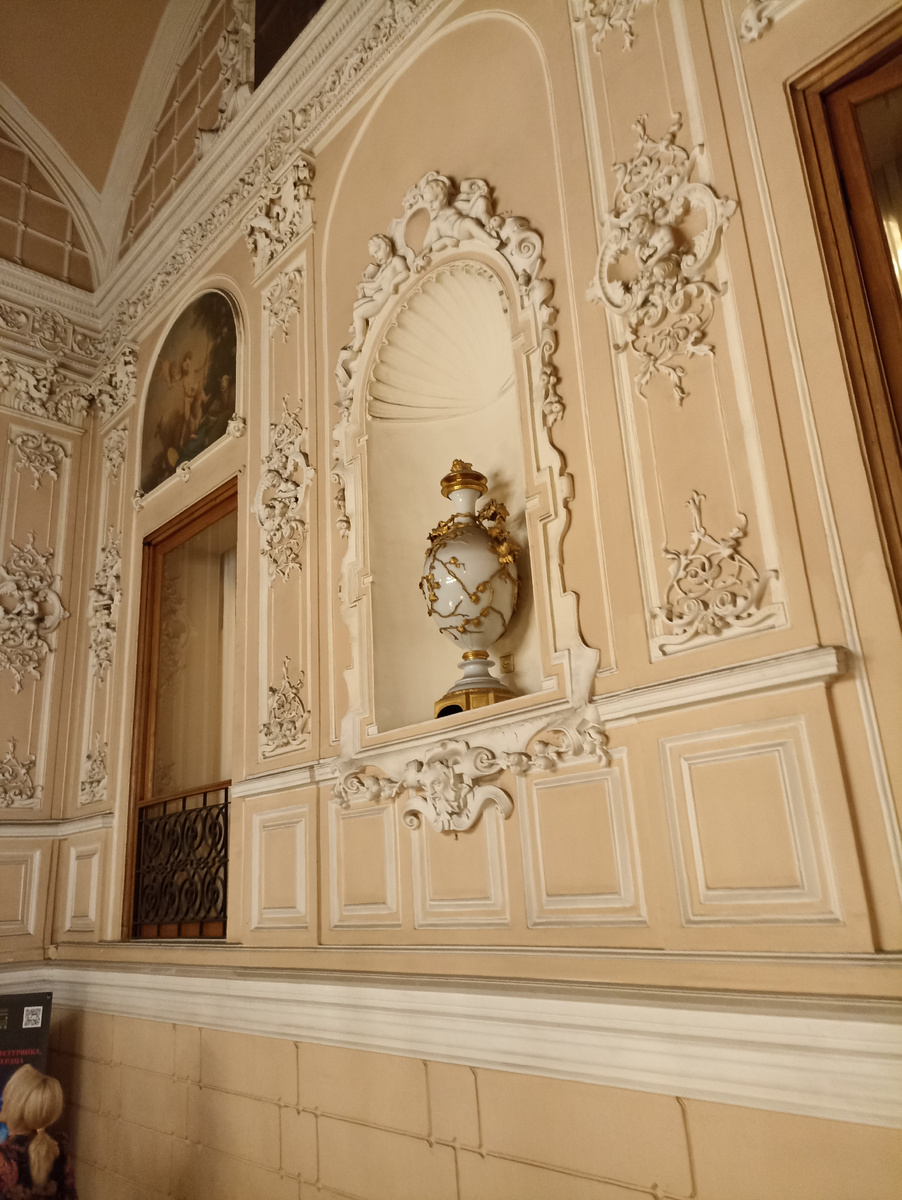 Ваза а и картинка. На стене лепнина. Так выглядит парадная лестница