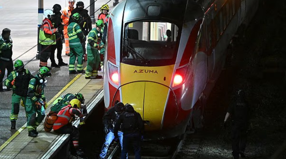 Сотрудники полиции и скорой помощи работают на платформе возле поезда LNER