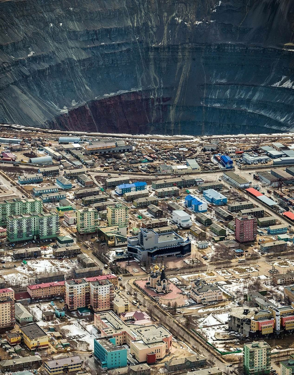 Карьер с высоты самолёта на фоне города 