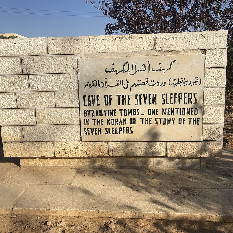 Знак у пещеры Семерых спящих в Иордании с указанием на то, что это место упоминается в Священном Коране / Источник: en.wikipedia.org
