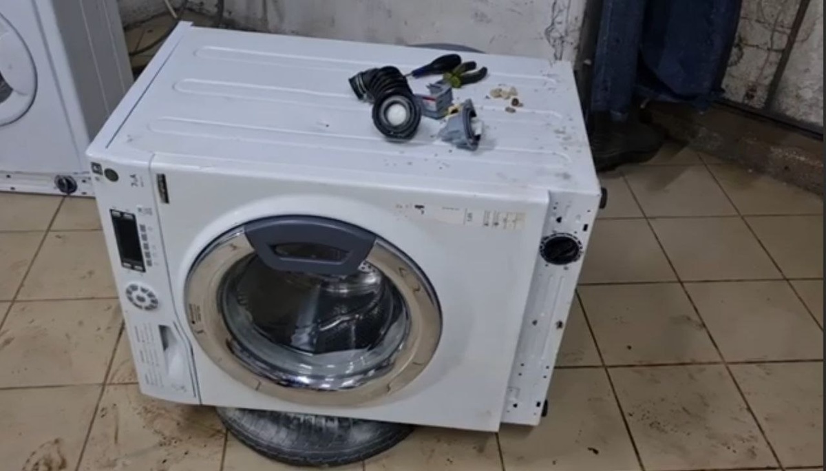 Для замены сливного насоса на стиральной машине её необходимо положить на левую сторону, на сторону лотка‑приёмника порошка, чтобы остатки воды в лотке и патрубке не попали на электронику. Тем самым электроника будет выше лотка. Далее вам потребуется отвёртка крестовая либо под звёздочку, чтобы открутить помпу‑насос. Не забудьте отключить стиральную машину от розетки.