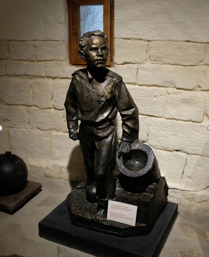 Скульптура Коли Пищенко в Оборонительной башне Малахова кургана. Возле него мортирка, из которой он стрелял по врагам. На груди можно заметить две медальки.