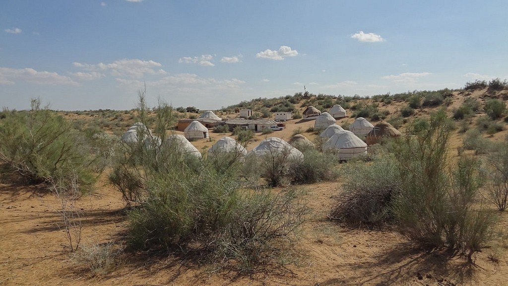 Ясное небо с редкими облаками и тёплый ветер подчёркивают ощущение простора и древнего кочевого уклада.