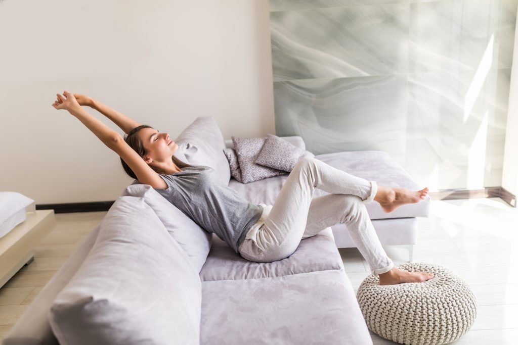    Closeup of a smiling young woman lying on couch admin