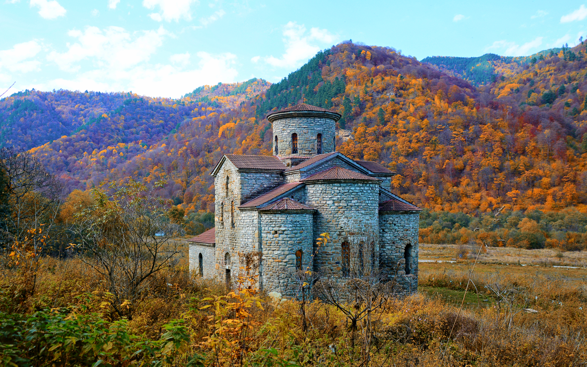 Вид на Средне-Зеленчукский храм X–XIII веков на фоне осенних гор. Архыз, Карачаево-Черкесия
