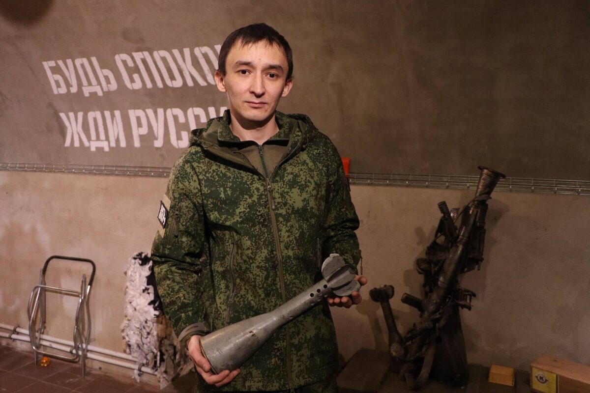 Глеб П. на рабочем месте – в музее, посвященном СВО, с одним из экспонатов – половиной от 120-й мины / Фото предоставлено Люцией Сиразеевой