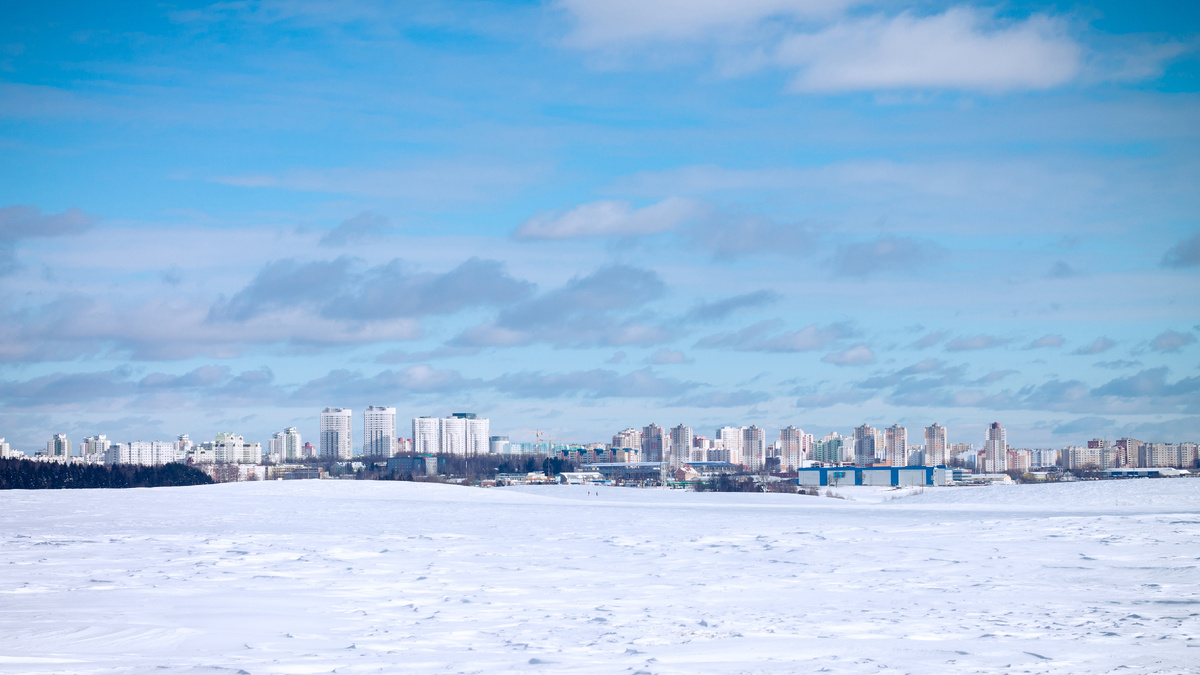 Пейзаж городских высотных зданий на фоне голубого неба и белого снега зимой. Республика Беларусь. Источник фото: shutterstock.com