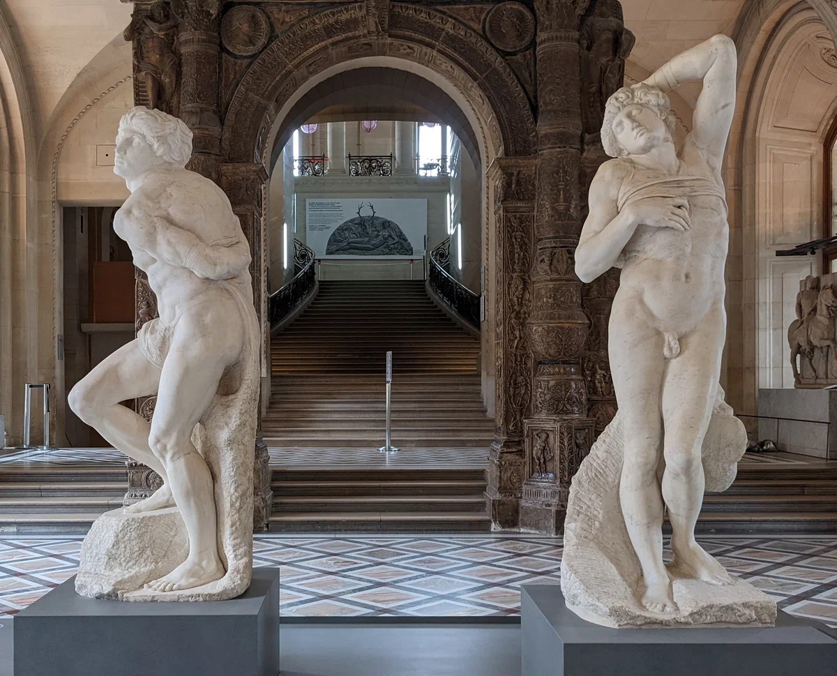 Микеланджело Буонаротти. Восставший (скованный) раб [слева] и Умирающий раб [справа. (1513-1516)]. Часть неоконченной композиции "Рабы" для надгробия римского папы Юлия II. Лувр (Париж, Франция)