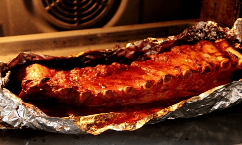 Разверните фольгу и смажьте ребрышки остатками маринада
