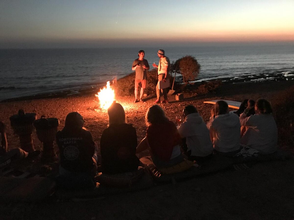 Участники серф-кемпа на вечерней "свечке" у костра на берегу Атлантического океана