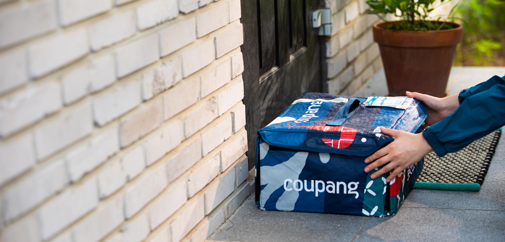 Сотрудник службы доставки Coupang рано утром кладёт многоразовый термопакет Fresh Bag на порог дома клиента. Будучи эксклюзивным для участников программы «Coupang Wow», пакет сохраняет свежесть охлажденных продуктов до момента их получения и забирается вместе со следующим заказом. Это часть системы, которая предлагает неограниченную «предрассветную» доставку свежих товаров стоимостью свыше 15 000 вон (10,27 долл. США) за ежемесячный членский взнос в размере 7890 вон (5,40 долл. США). Также в него входит неограниченная ночная доставка других товаров первой необходимости и продуктов без минимальной суммы заказа (Coupang)