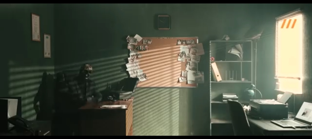 Мориарти в образе "аналитика" сидит за столом в полумраке, на фоне — доска с фотографиями и связями, как в детективном фильме. Этот антураж — ключевой элемент манипуляции, создающий ложный образ эксперта, которому можно доверять.