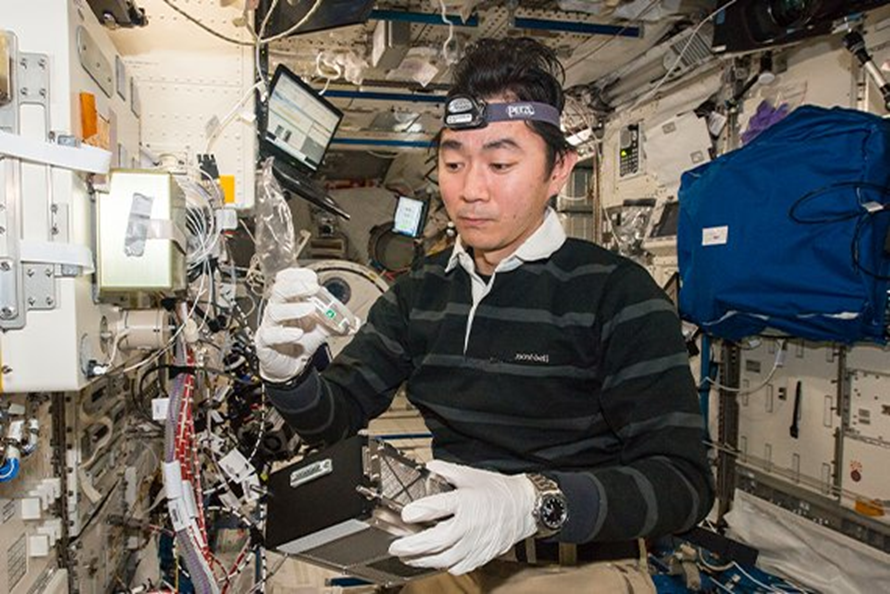 Кимия Юи работает с биотехнологическими образцами на МКС. Фото: spacenews.com