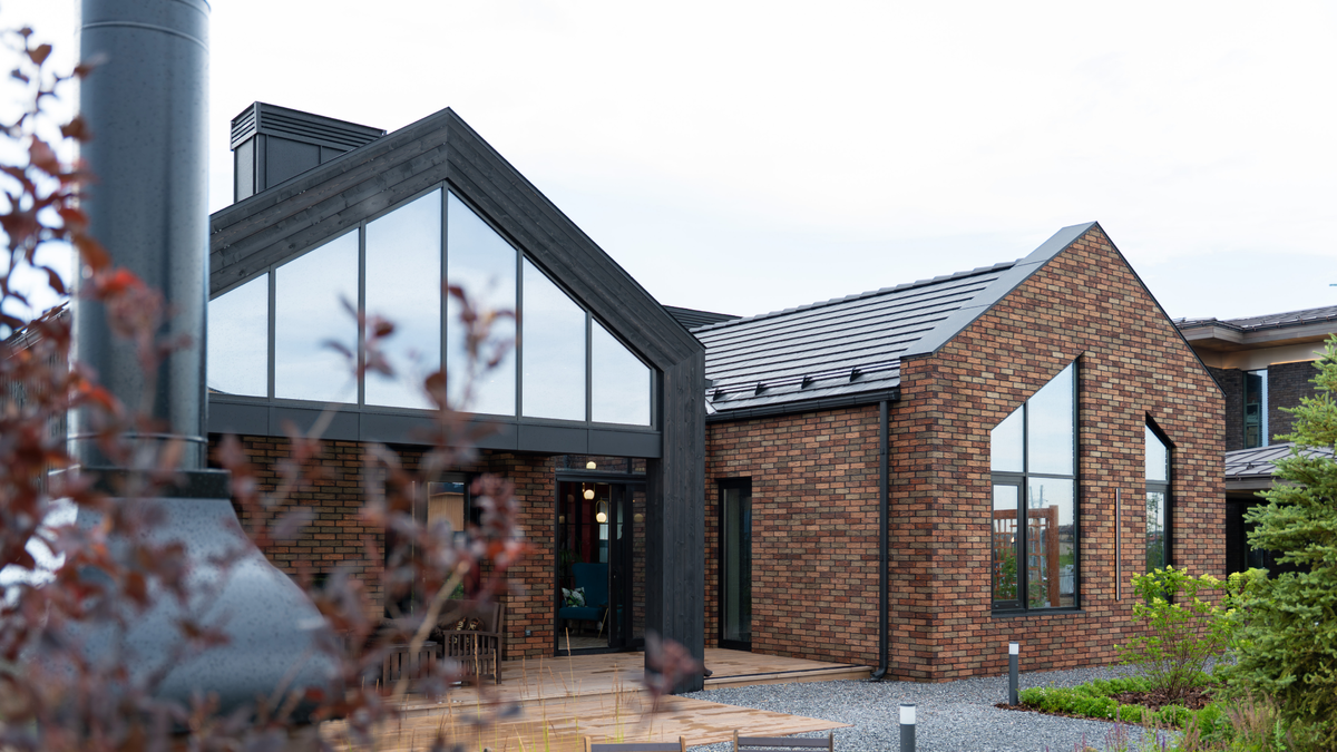 Панорамное окно в форме трапеции придает классической архитектуре современные черты и наполняет внутреннее пространство светом