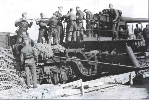 Расчет заряжает 150-мм орудие. Все орудия крупного калибра имели раздельное заряжение. Первым в казенную часть закладывался снаряд, затем - заряд. На снимке хорошо видна опора орудийной платформы, частично поглощающая энергию отката и позволяющая орудию поворачиваться без опрокидывания железнодорожного транспортера. Конструкторы всегда старались расположить центр тяжести тяжелой железнодорожной артсистемы как можно ниже, чтобы транспортер не перевернуло при выстреле или при движении на кривой малого радиуса. Масса орудия распределена на шесть колесных пар, объединенных в две тележки.