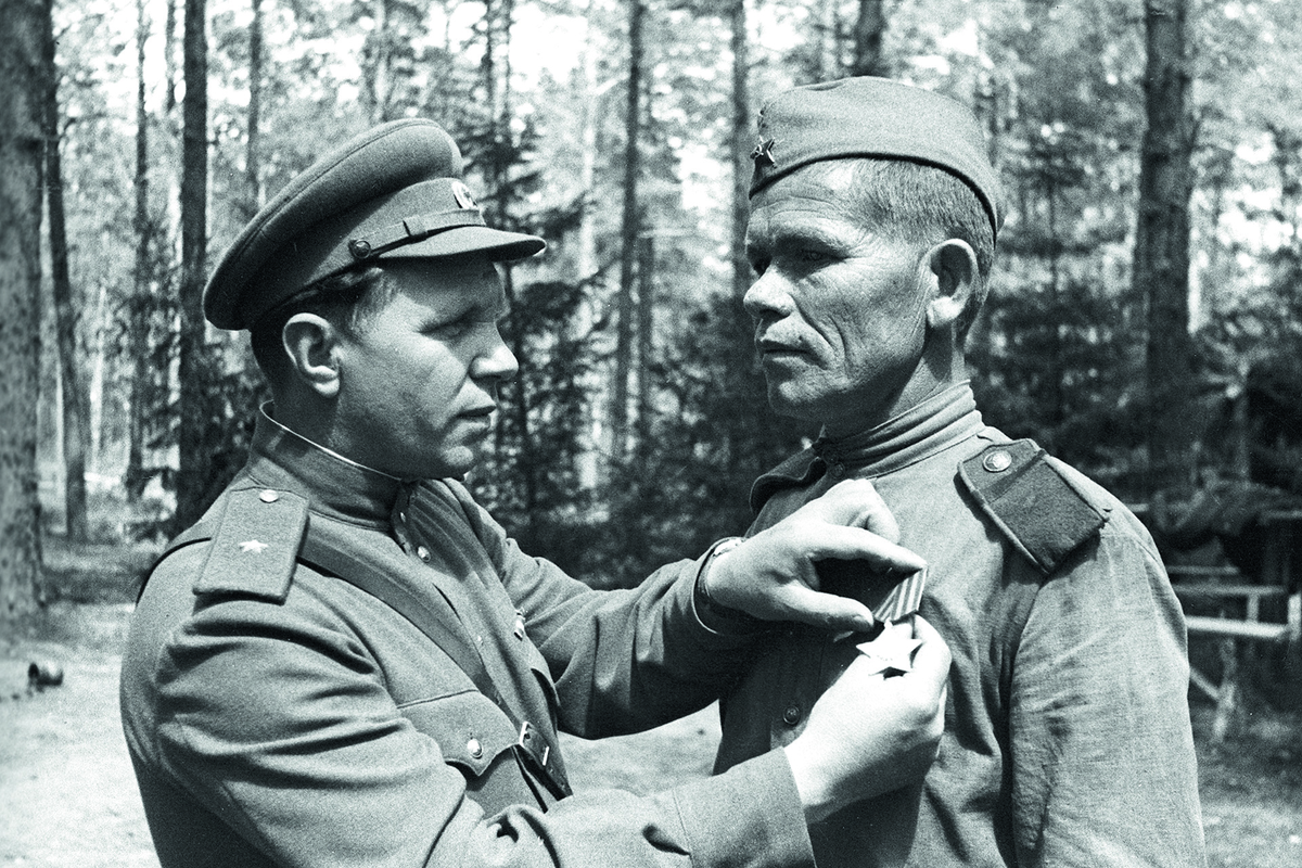 Командир 399-й стрелковой дивизии генерал-майор Д.В. Казакевич прикрепляет орден Славы старшему сержанту Василию Матросову. 1944 г.