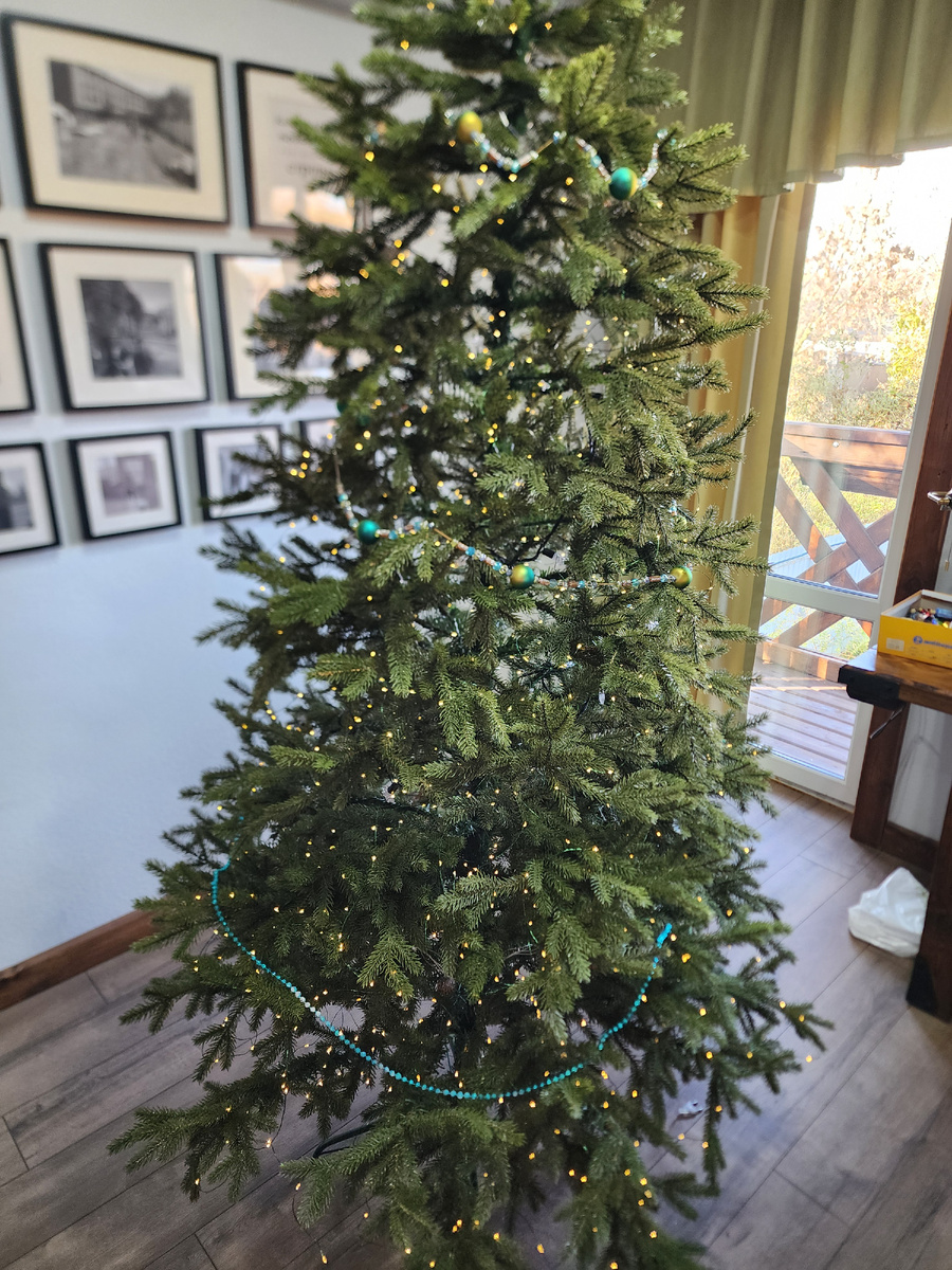 Здесь горит пока только белая гирлянда, у цветной провод покороче, необходимо подвинуть ель ближе к розетке)