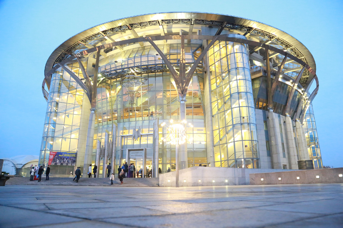 Фасад Московского международного Дома музыки (ММДМ) представляет собой современное круглое здание с панорамным сплошным остеклением. Он построен из стекла и металла, что придает ему современный вид и выделяет на фоне других зданий комплекса «Красные холмы». 