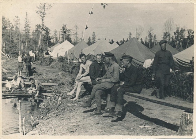 Первостроители города на фоне палаток