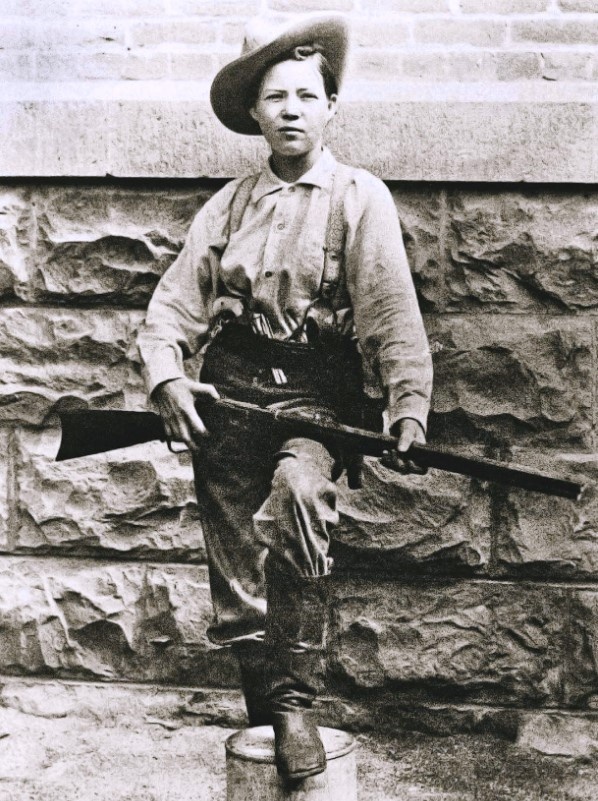 Канадская грабительница Перл Харт (урождённая Тейлор), в мужской одежде, с винтовкой Winchester '73 и кольтом на поясе