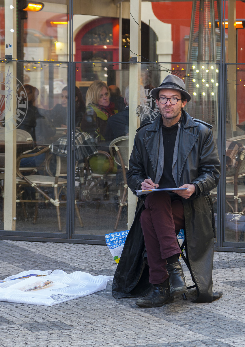 На первом плане глвный герой, диагонали покрытия мостовой ведут взгляд зрителя. Рамы витринных стекол создают рамку вогруг его фигуры. Женщина на заднем плане смотрит на уличного художника, поддерживая его как центральный объект. Фигура мужчины освещена и выделена контрастом.