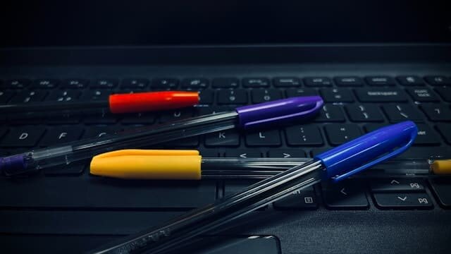 Ноутбук с шариковыми ручками. Фото: unsplash.com